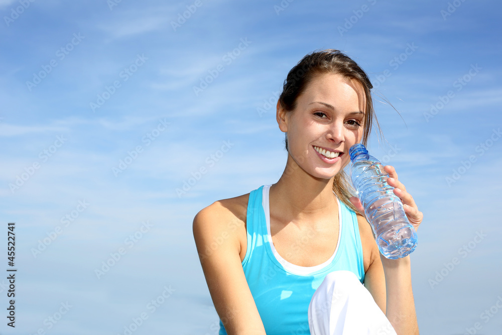 Thirsty fitness girl holding bottle of water Thirsty fitness girl holding bottle of water