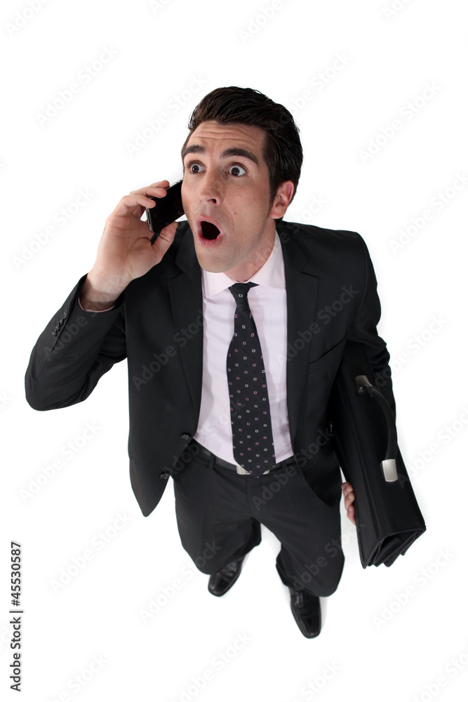 Surprised businessman with telephone and briefcase Surprised businessman with telephone and briefcase