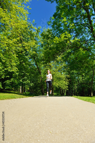 Young beautiful woman jogging at morning in park