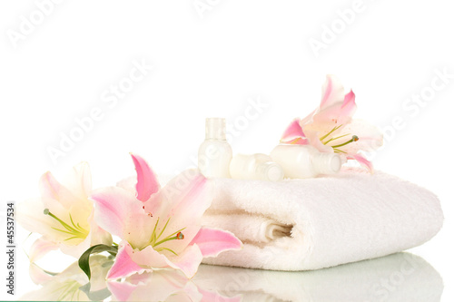beautiful lily with towel and bottles isolated on white