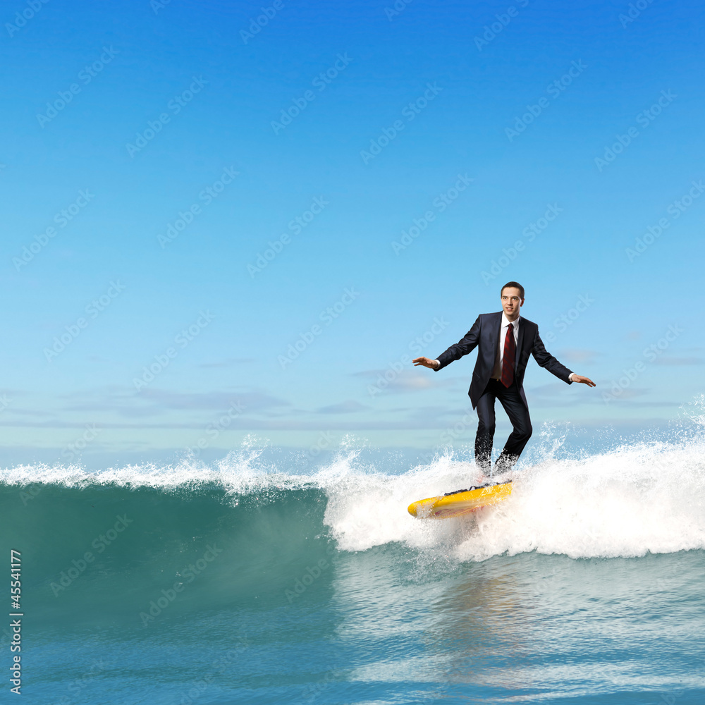 Businessman surfing on the waves of the ocean Businessman surfing on the waves of the ocean