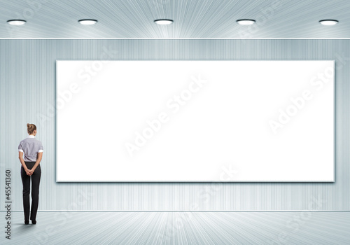 Business person standing near a blank billboard