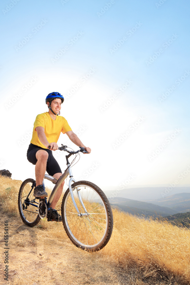 A view of a young biker riding a mountain bike on a sunset A view of a young biker riding a mountain bike on a sunset