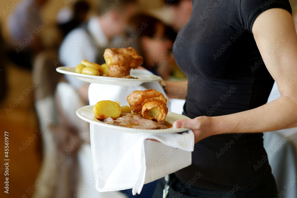 Waitress carrying two plates with meat dish Waitress carrying two plates with meat dish