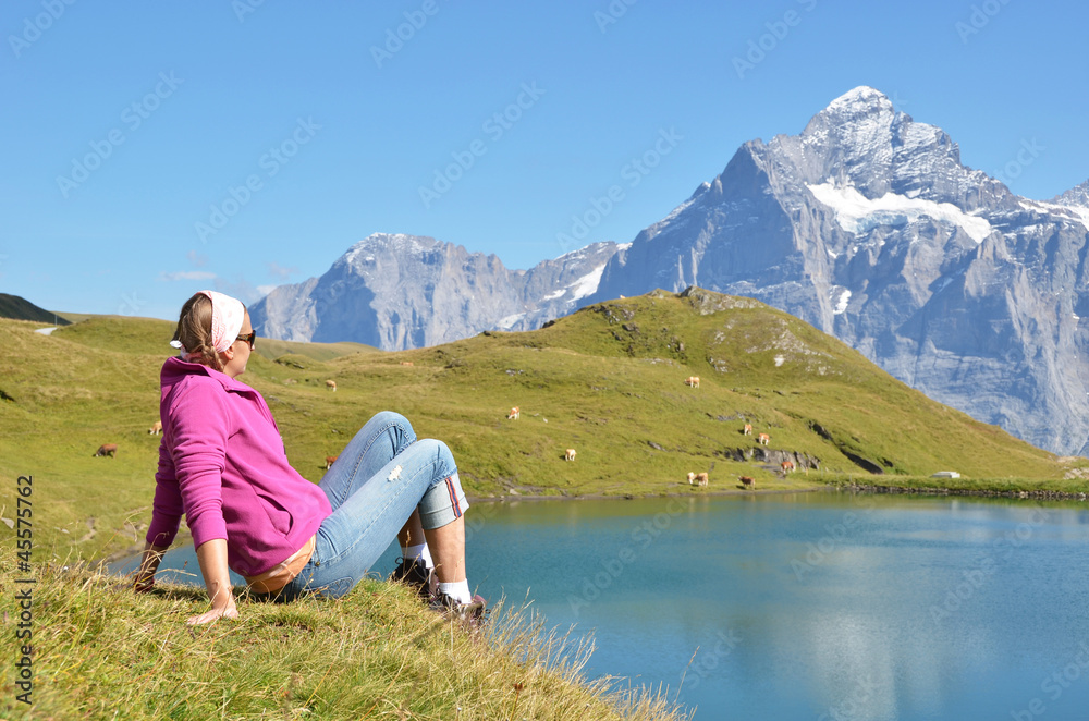 Fototapeta premium Traveler in the Alpine meadow. Jungfrau region, Switzerland