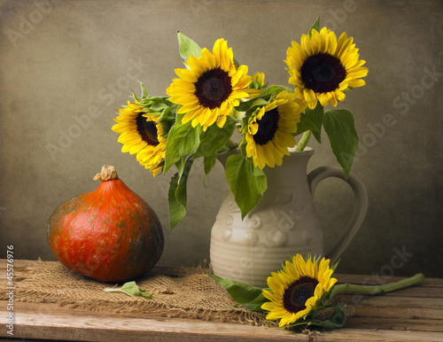 Still life with sunflower bouquet and pumpkin on wooden table