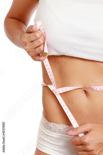 A slim girl measuring her waist, closeup, isolated on white