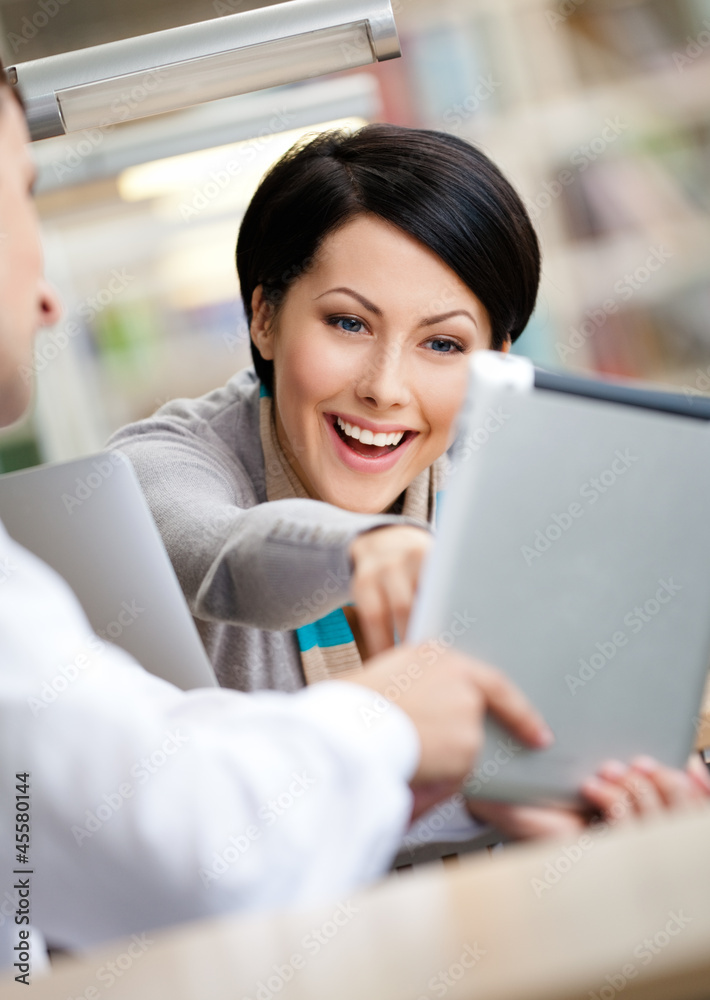 Woman communicates with man showing her something in the pad Woman communicates with man showing her something in the pad