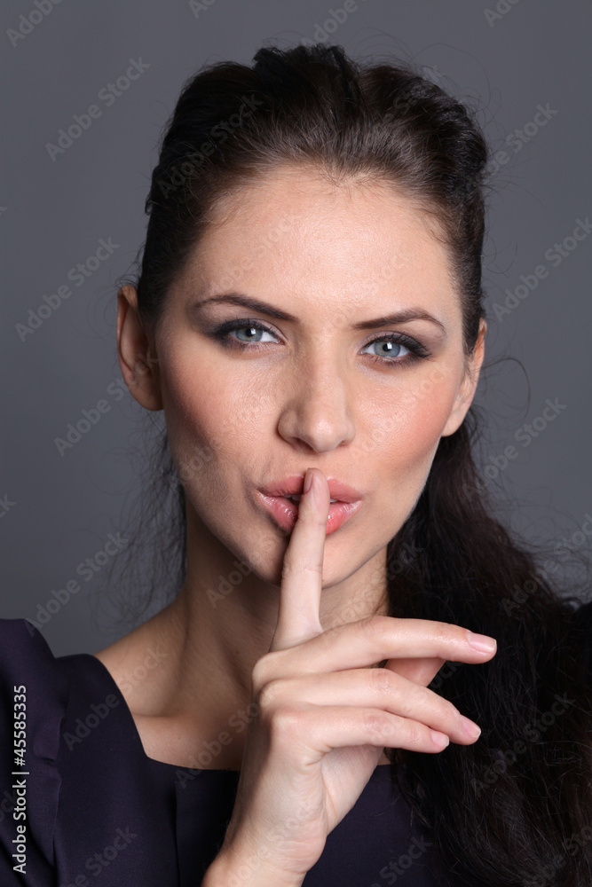 woman with a finger on her lips showing to keep silence