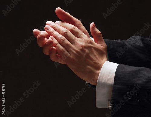 Canvas Print Male hands clapping on black, side-view
