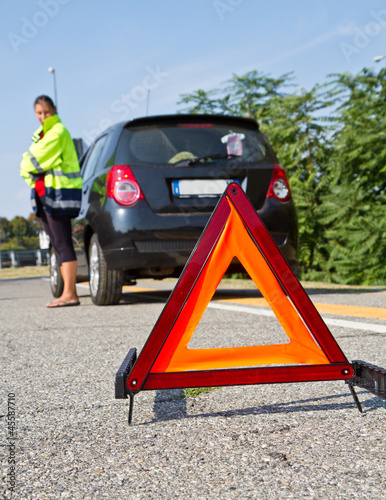 Broken down car with red warning triangle