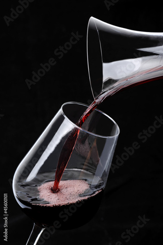 Red Wine pouring into glass from decanter