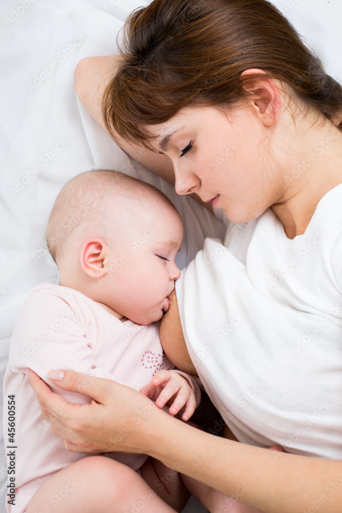 relaxed mother breast feeding her baby girl relaxed mother breast feeding her baby girl