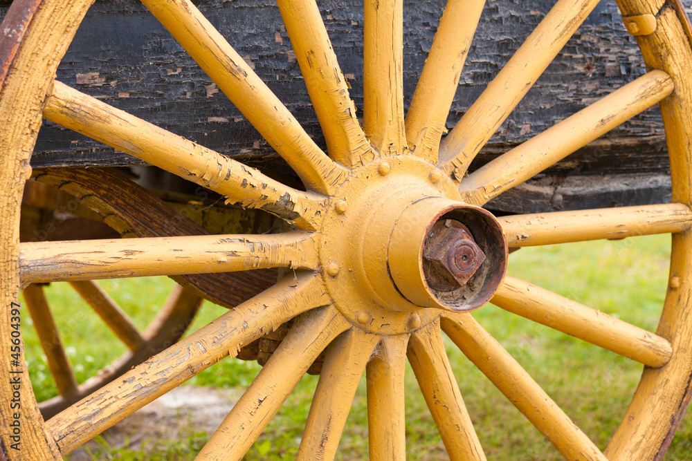 Old painted yellow wagon wheel on historic cart Old painted yellow wagon wheel on historic cart