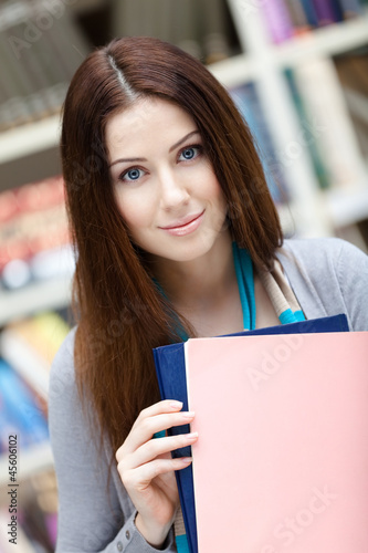 Female student with books at the library. Research