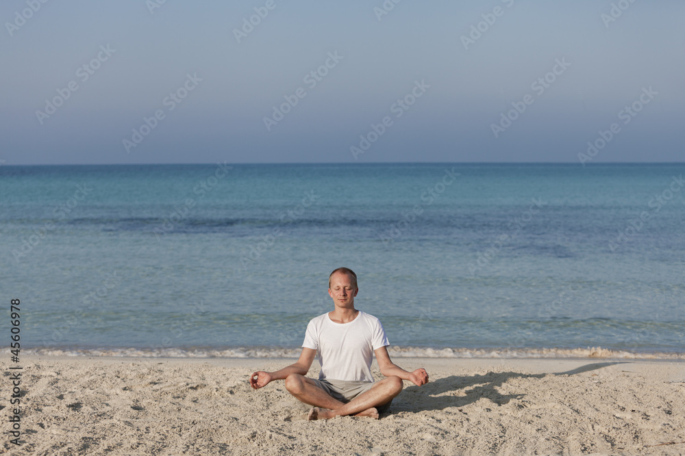 Mann macht yoga Sport am Strand Querformat
