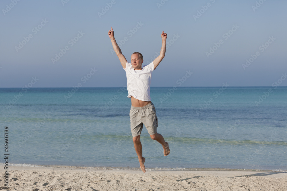 Fröhlicher Mann springt lachend am Strand Querformat Fröhlicher Mann springt lachend am Strand Querformat