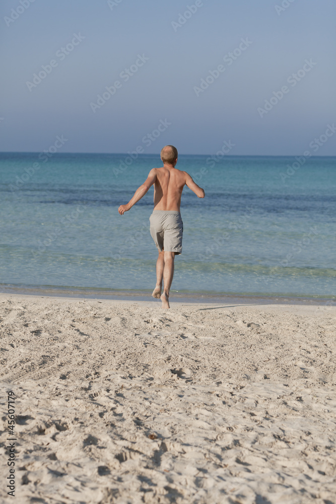 mann rennt am strand im Wasser Hochformat mann rennt am strand im Wasser Hochformat
