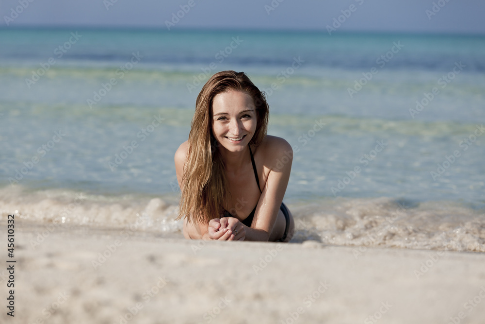 Junge Frau mit schwarzem Bikini am Strand im Wasser Querformat Junge Frau mit schwarzem Bikini am Strand im Wasser Querformat