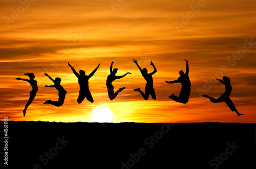 silhouette of friends jumping on beach in sunset © Alex Koch