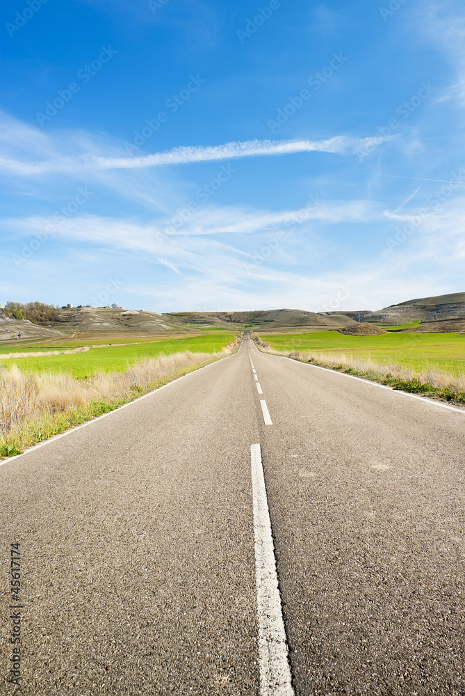 Rural road across the field.Road Running Through Fields Rural road across the field.Road Running Through Fields