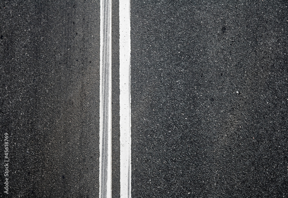 Fototapeta premium Close-up texture of an asphalt road with marking