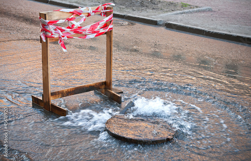 Danger border near water leak on the road photo