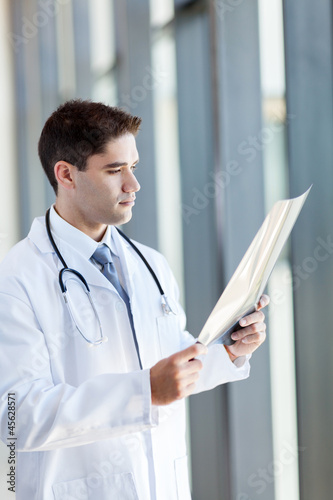 thoughtful doctor looking at patient's x-ray film