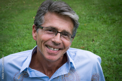 Fotografía homme souriant assis dans l'herbe