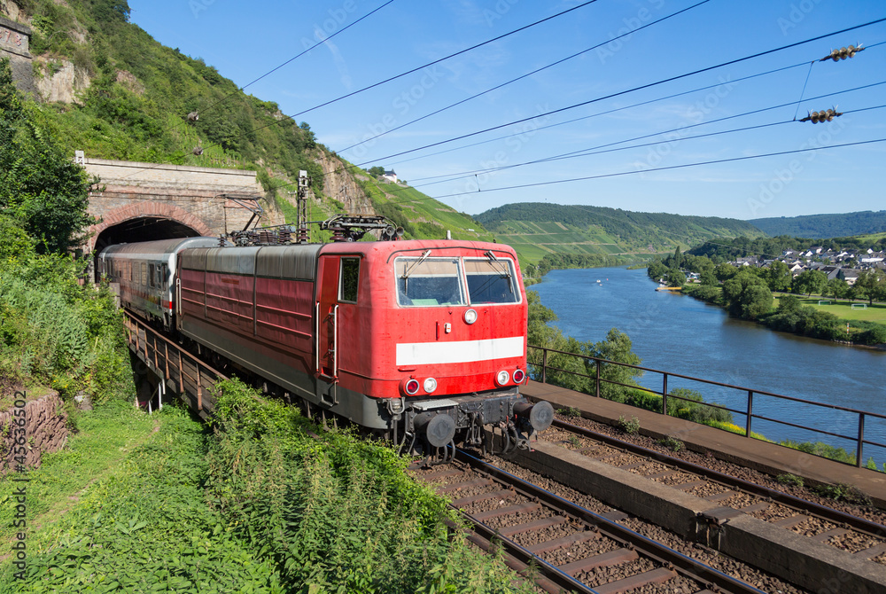 Train leaving a tunnel near the river Moselle in Germany Train leaving a tunnel near the river Moselle in Germany