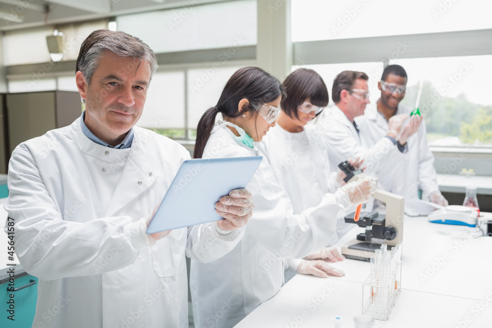 Smiling chemist using tablet pc