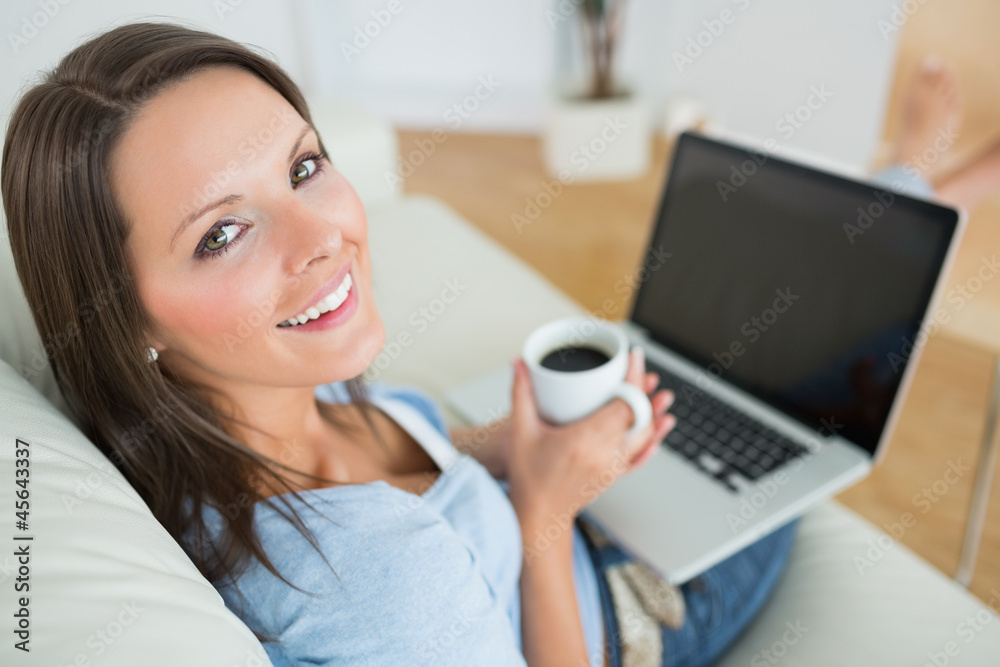 Woman drinking a coffee and using her laptop Woman drinking a coffee and using her laptop