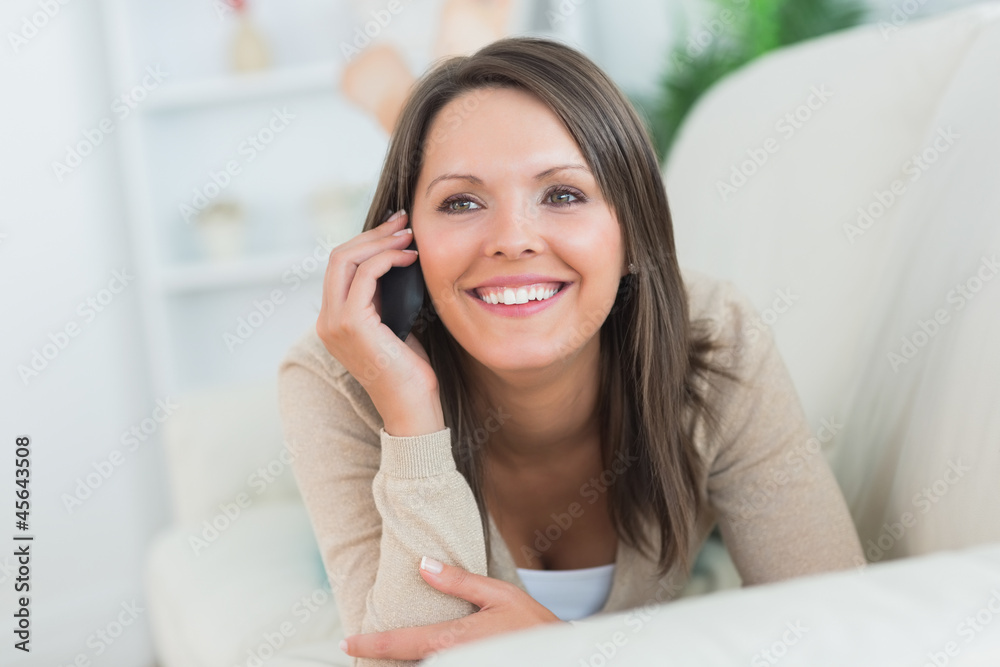 Cheerful woman lying on the sofa and calling Cheerful woman lying on the sofa and calling