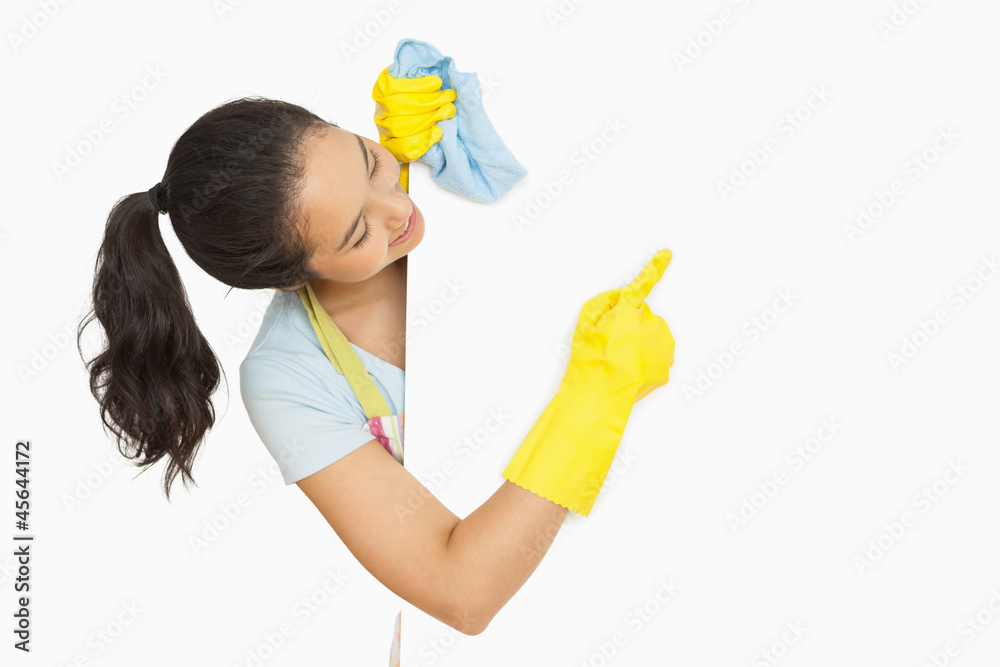 Happy woman pointing to white surface she is cleaning Happy woman pointing to white surface she is cleaning