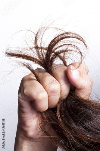 Woman hand with damaged hair