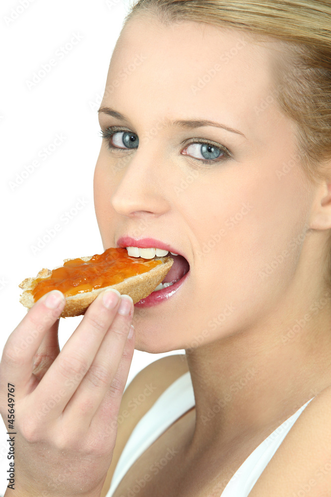Woman eating a piece of bread with jam Woman eating a piece of bread with jam