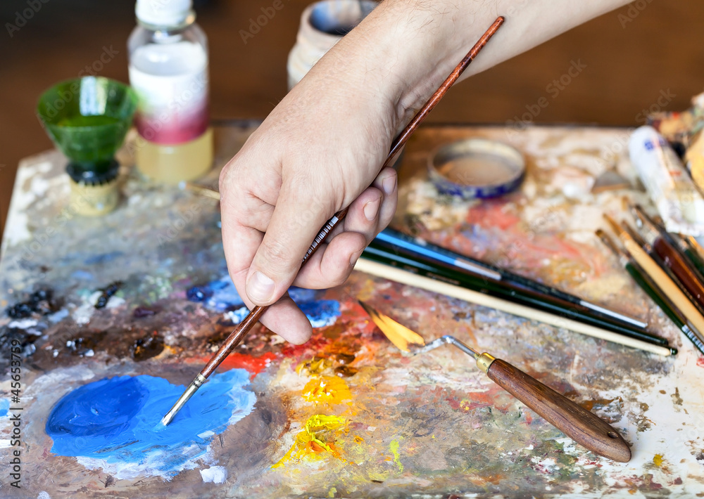 Fototapeta premium Hand of the artist with a paintbrush