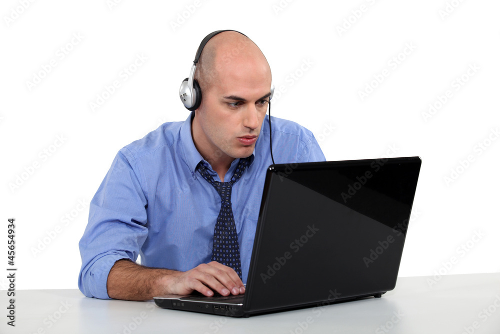 Businessman with laptop and headphones