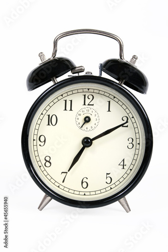 A classic old black alarm clock on white background