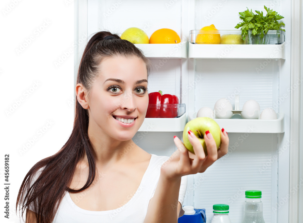 cute girl with apple near the open refrigerator cute girl with apple near the open refrigerator