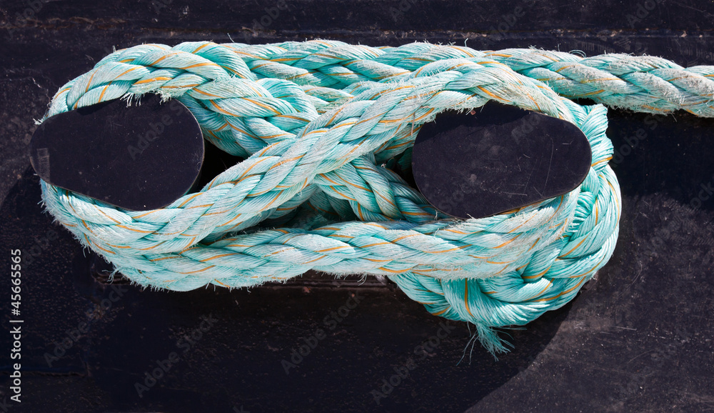 Bundle of rope on the ship mooring bollard