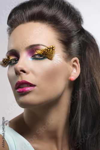 girl with feathered makeup turned at right