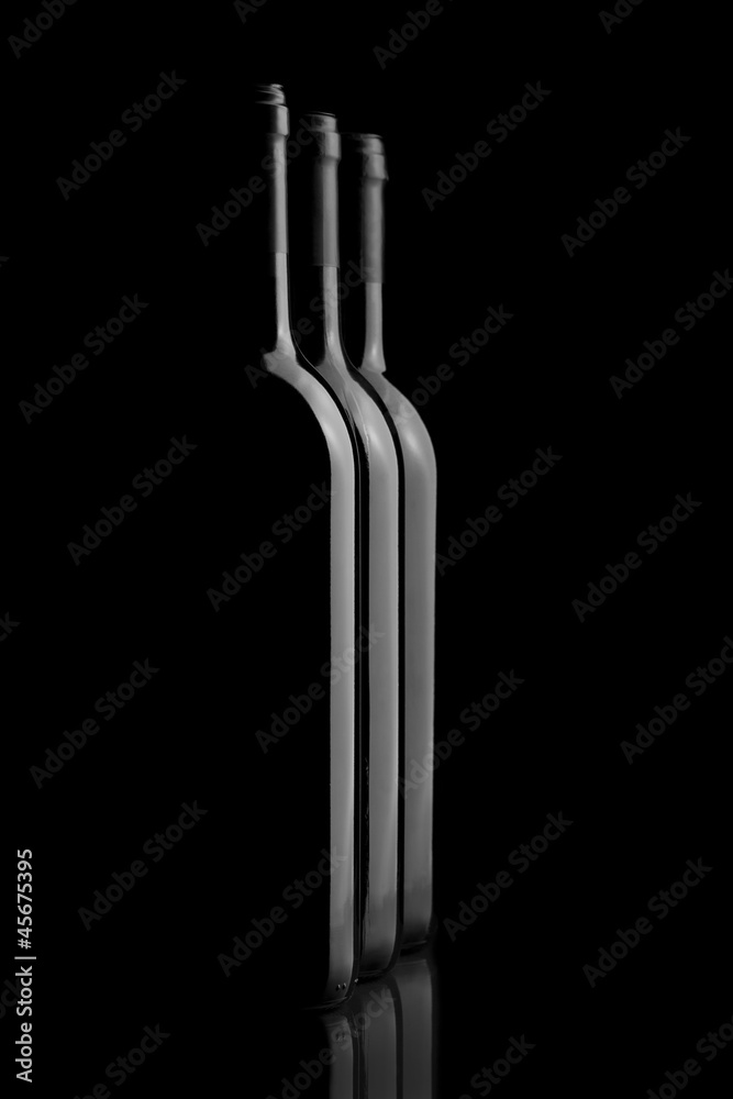Three elegant wine bottles in a black background Three elegant wine bottles in a black background