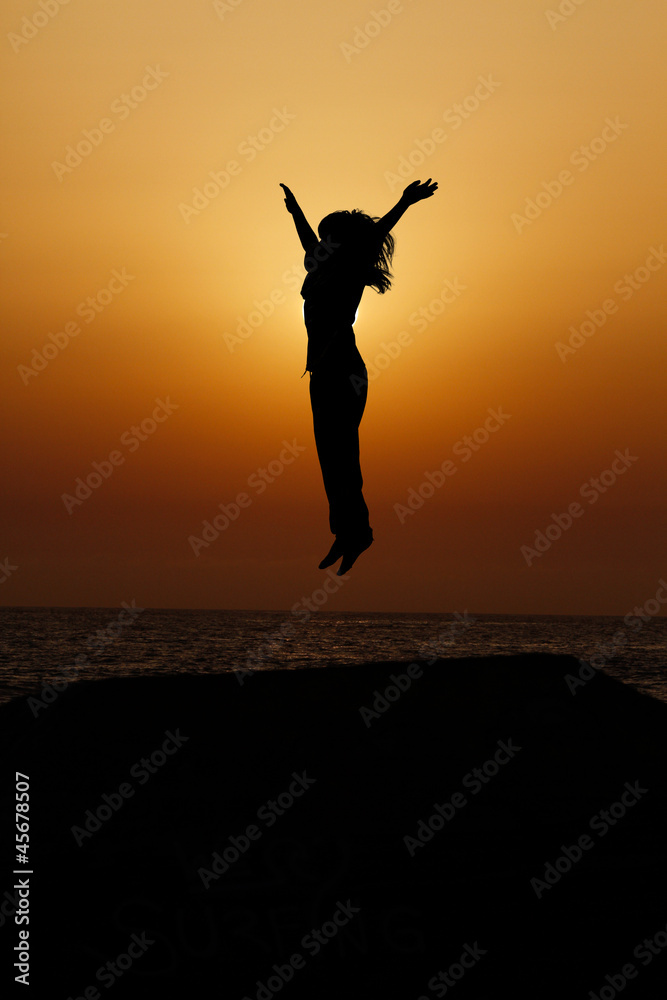 silhouette of child jumping in sunset