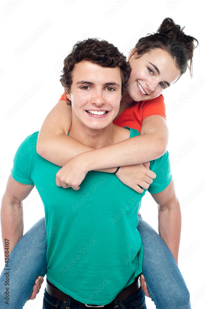 Casual shot of young guy giving piggy ride to his partner Casual shot of young guy giving piggy ride to his partner