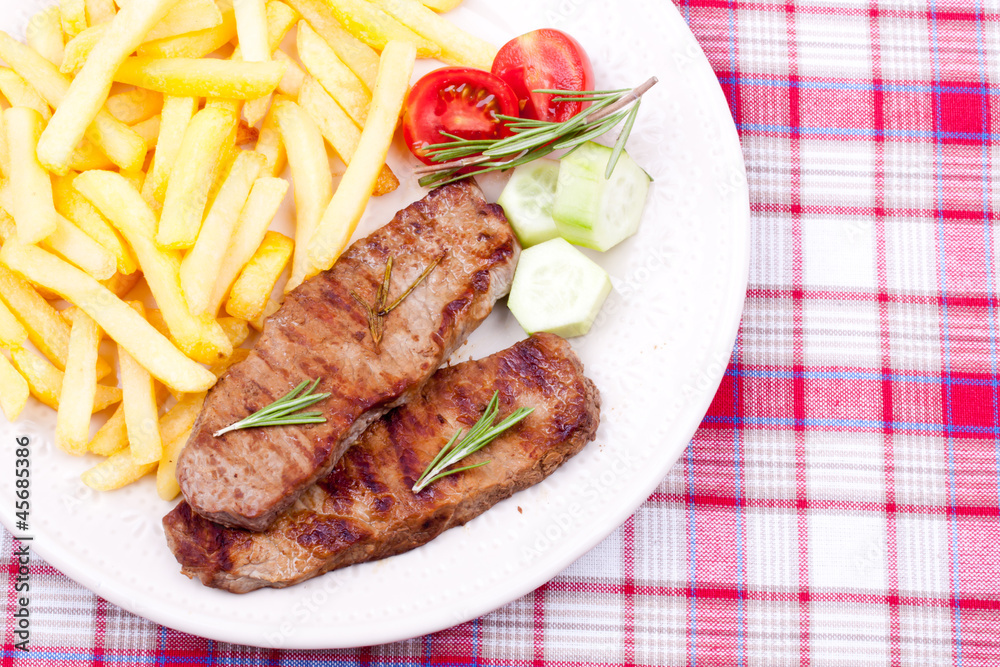 grilled steak with french fries and salad