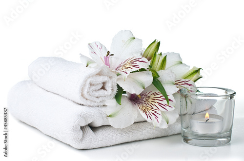 resources for spa, white towel, candle and flower