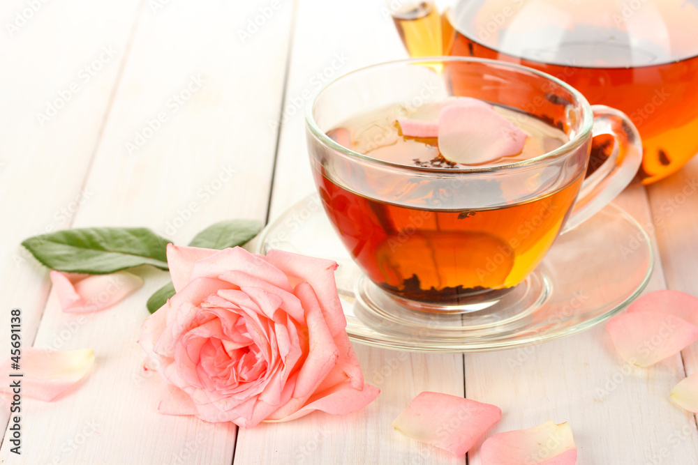 teapot and cup of tea with roses on white wooden table teapot and cup of tea with roses on white wooden table