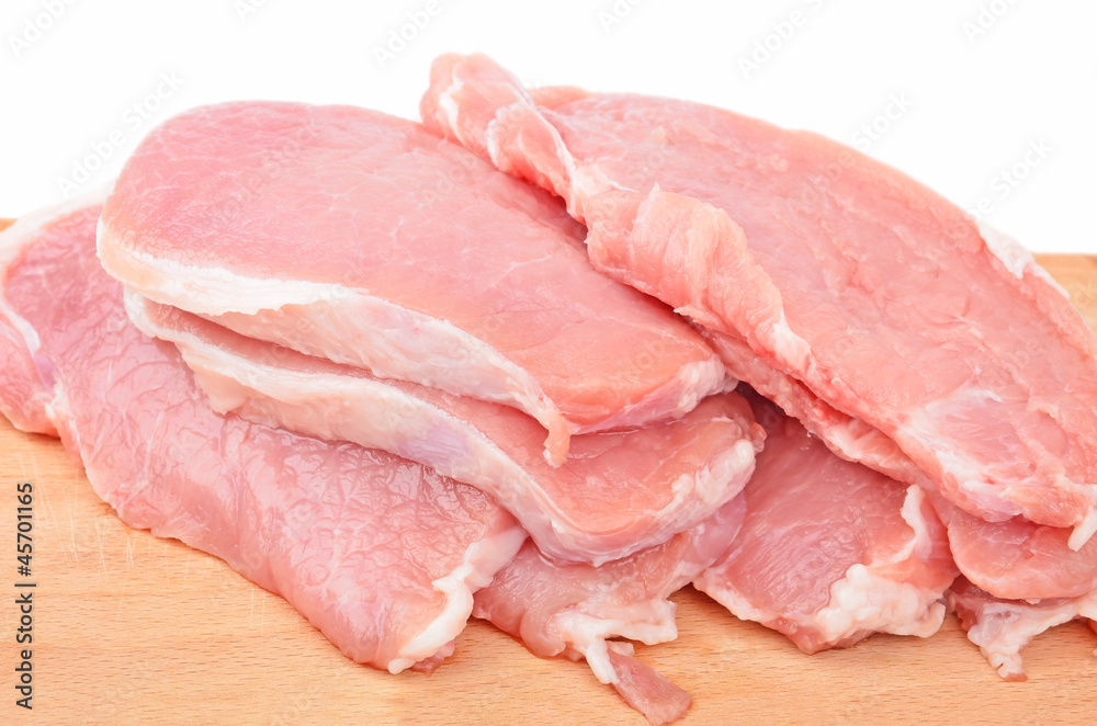 Raw meat steaks on wooden board, isolated on white background