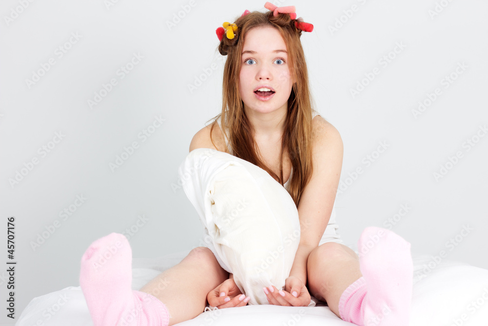 Beautiful woman sitting in bed with hair curlers Beautiful woman sitting in bed with hair curlers